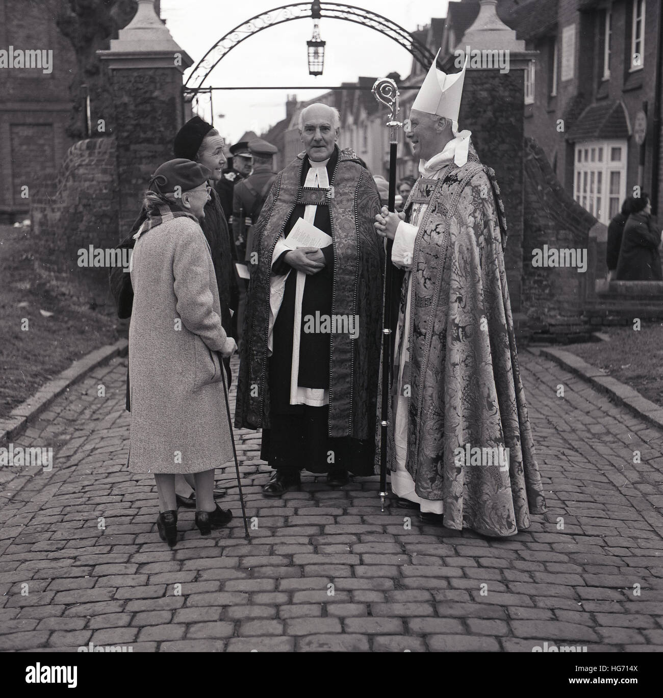 historische, der 1960er Jahre traf römischen katholischen Klerus Gemeindemitglieder außerhalb. Stockfoto