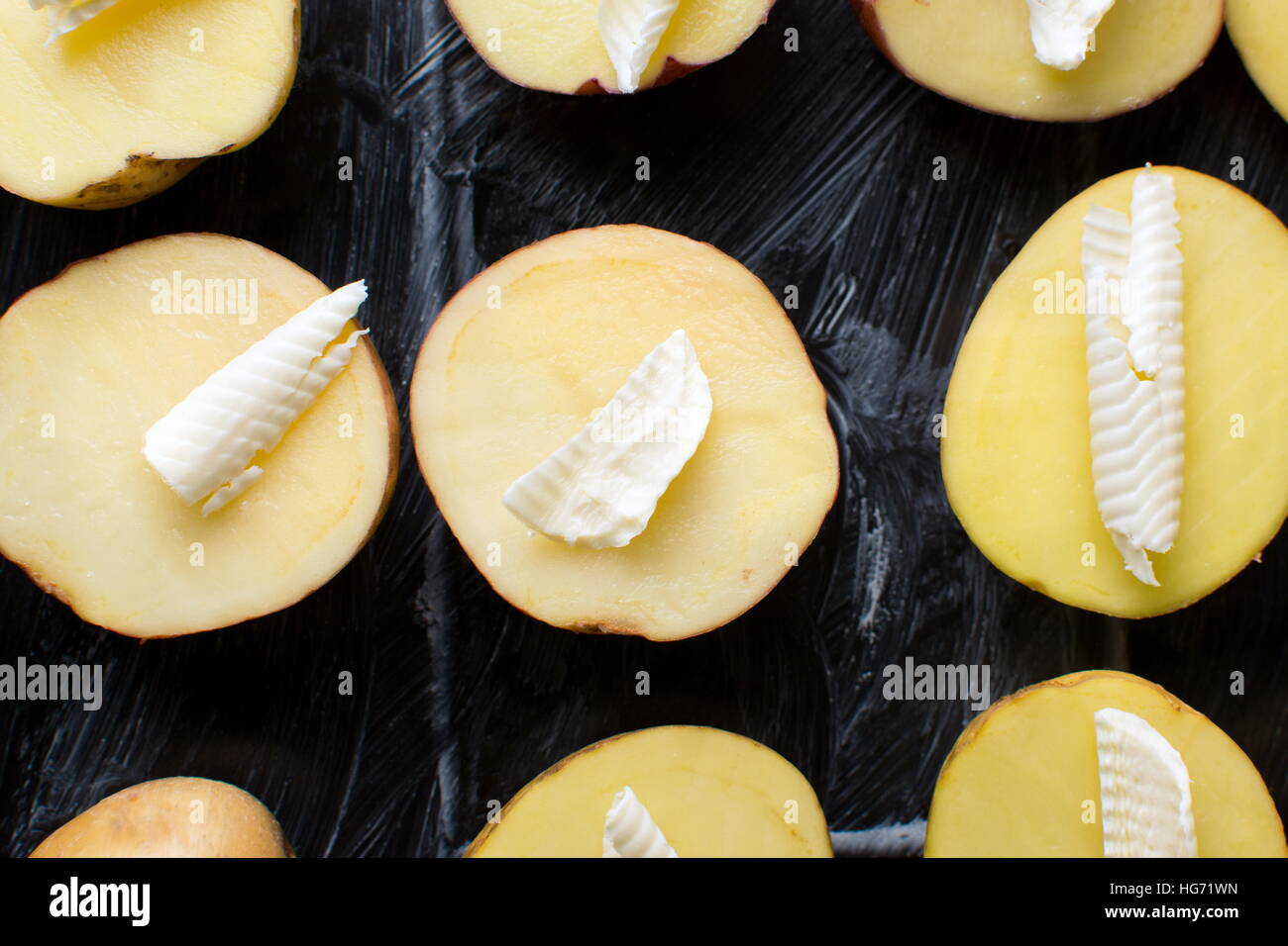 Kartoffel mit Butter auf einer schwarzen Platte Backen Stockfoto