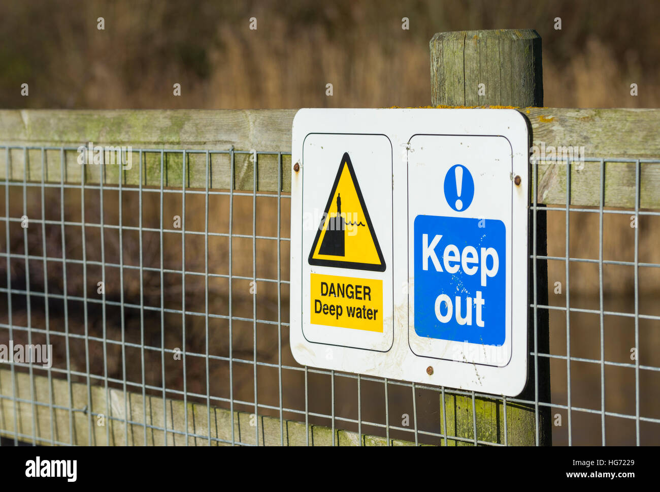 Zu halten, und Gefahr Tiefenwasser Zeichen angehängt an einen Zaun an einem kleinen See. Stockfoto