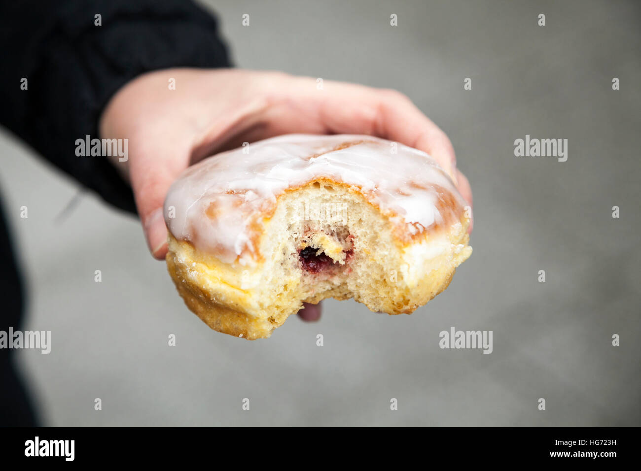 Frau hält einen Berliner (wie Donut) in Berlin Stockfoto