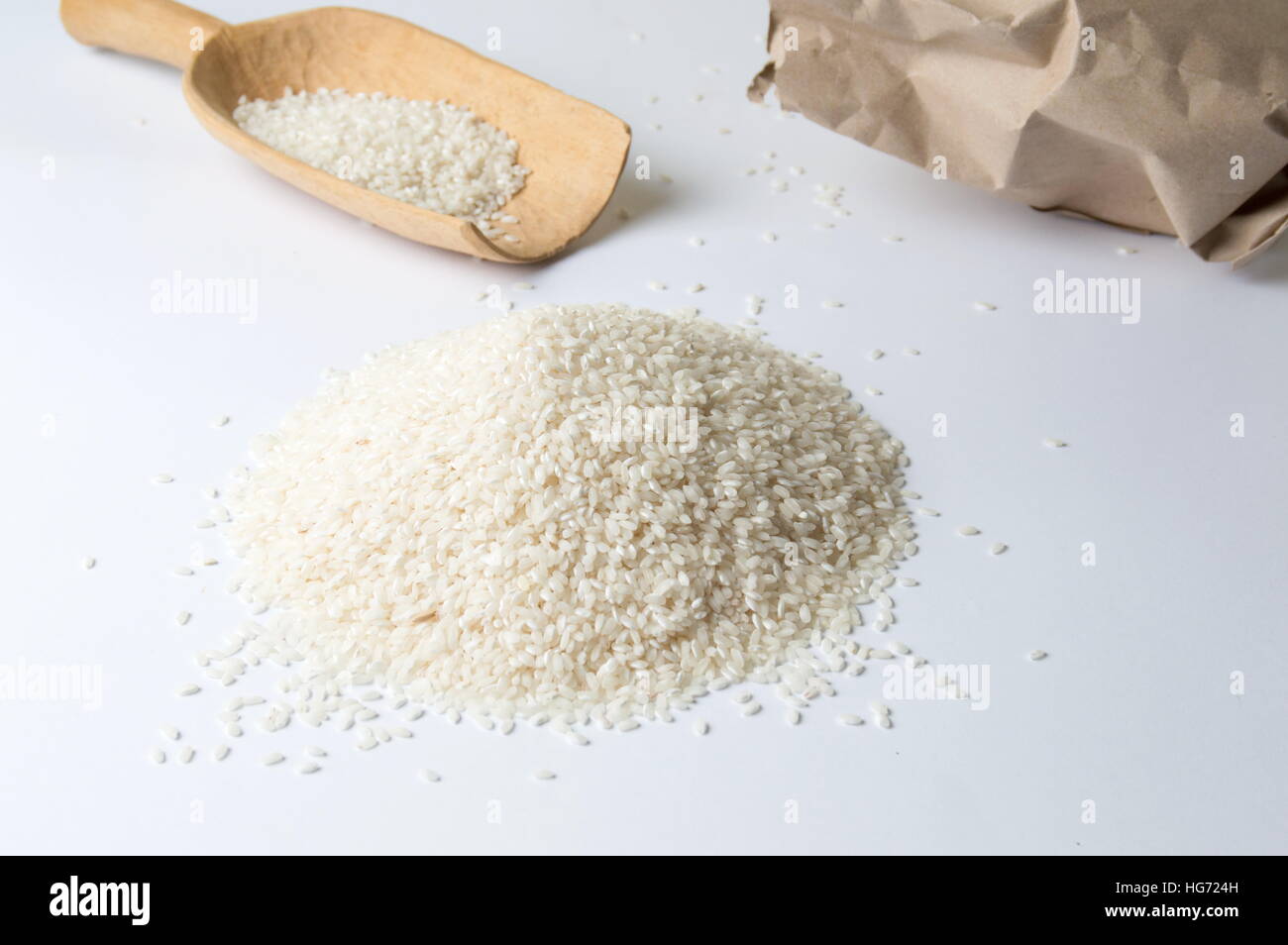 Weißer Reis, Holzlöffel und große Papiertüte Stockfoto