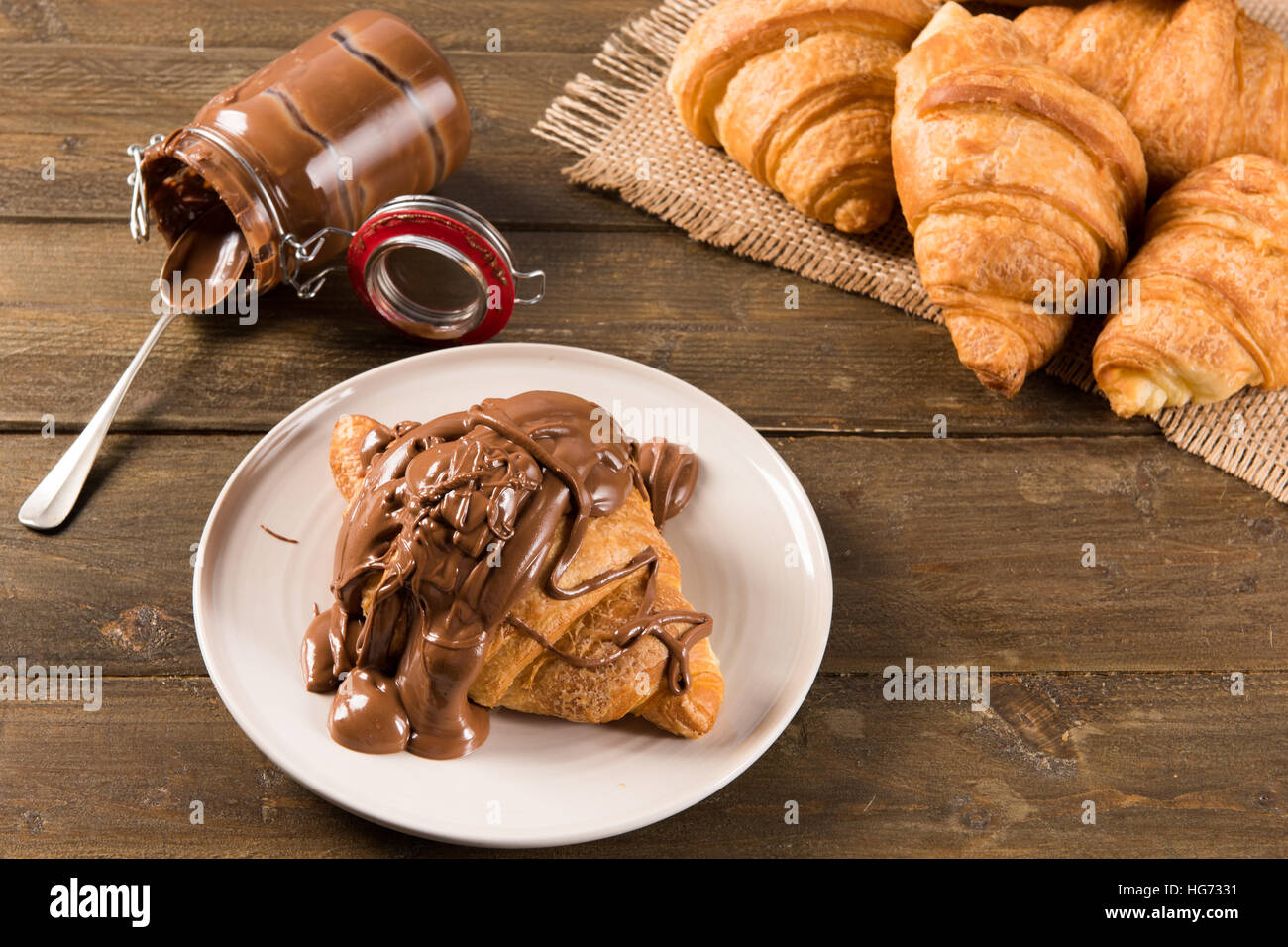 Croissant mit Schokocreme auf dem Tisch in natürlichem Licht Stockfoto