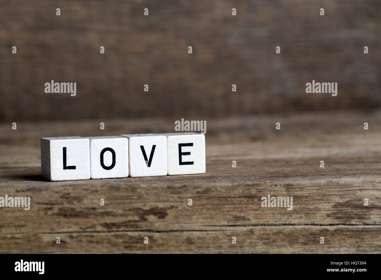 Liebe, geschrieben in Würfeln auf hölzernen Hintergrund Stockfoto