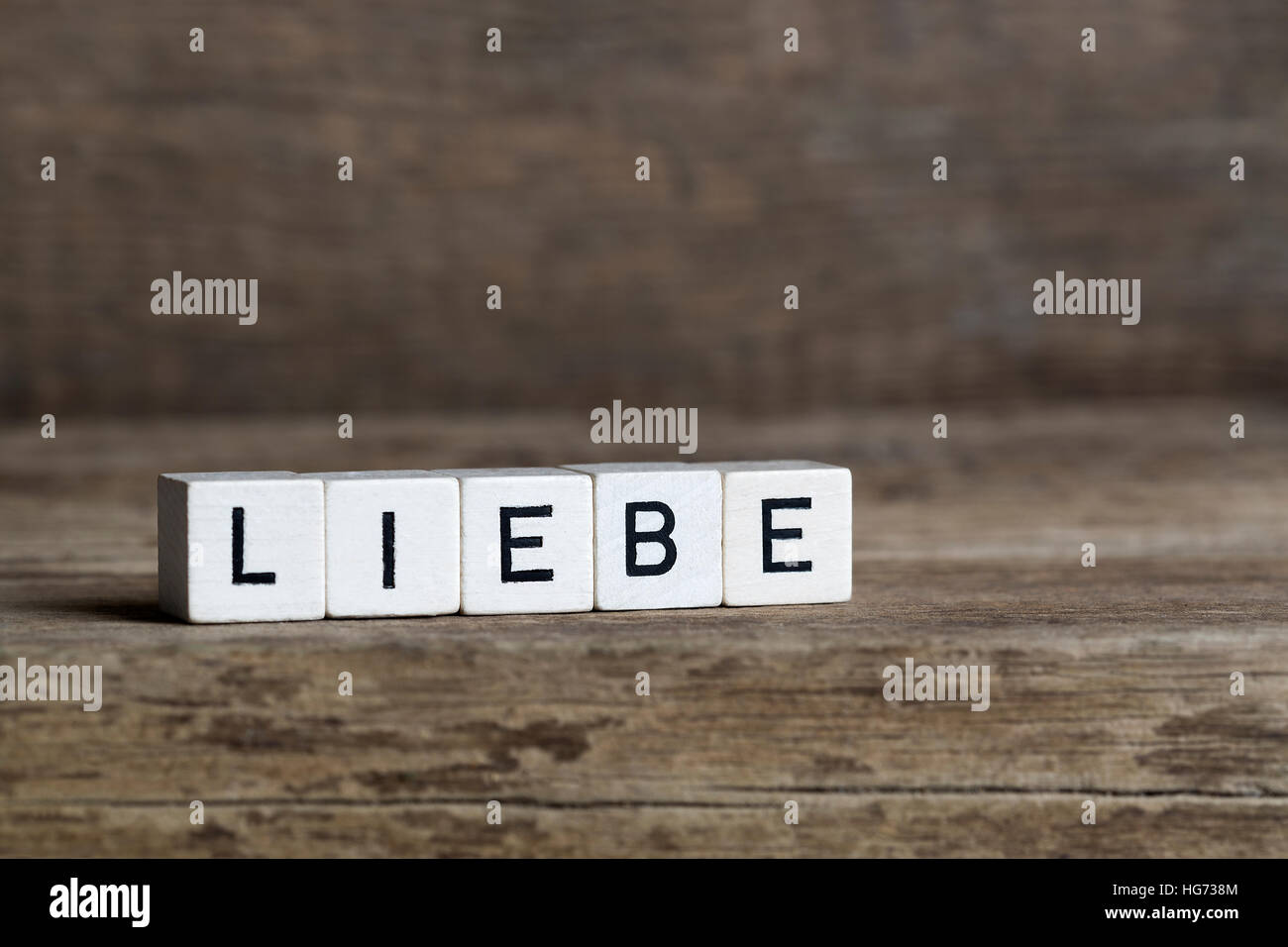 Deutsches Wort Liebe geschrieben am hölzernen Hintergrund Stockfoto