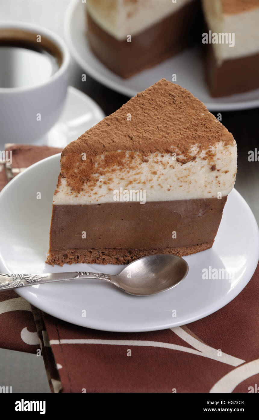 ein Stück Schokolade mit Vanille-Mousse Kuchen bedeckt Kakao Stockfoto