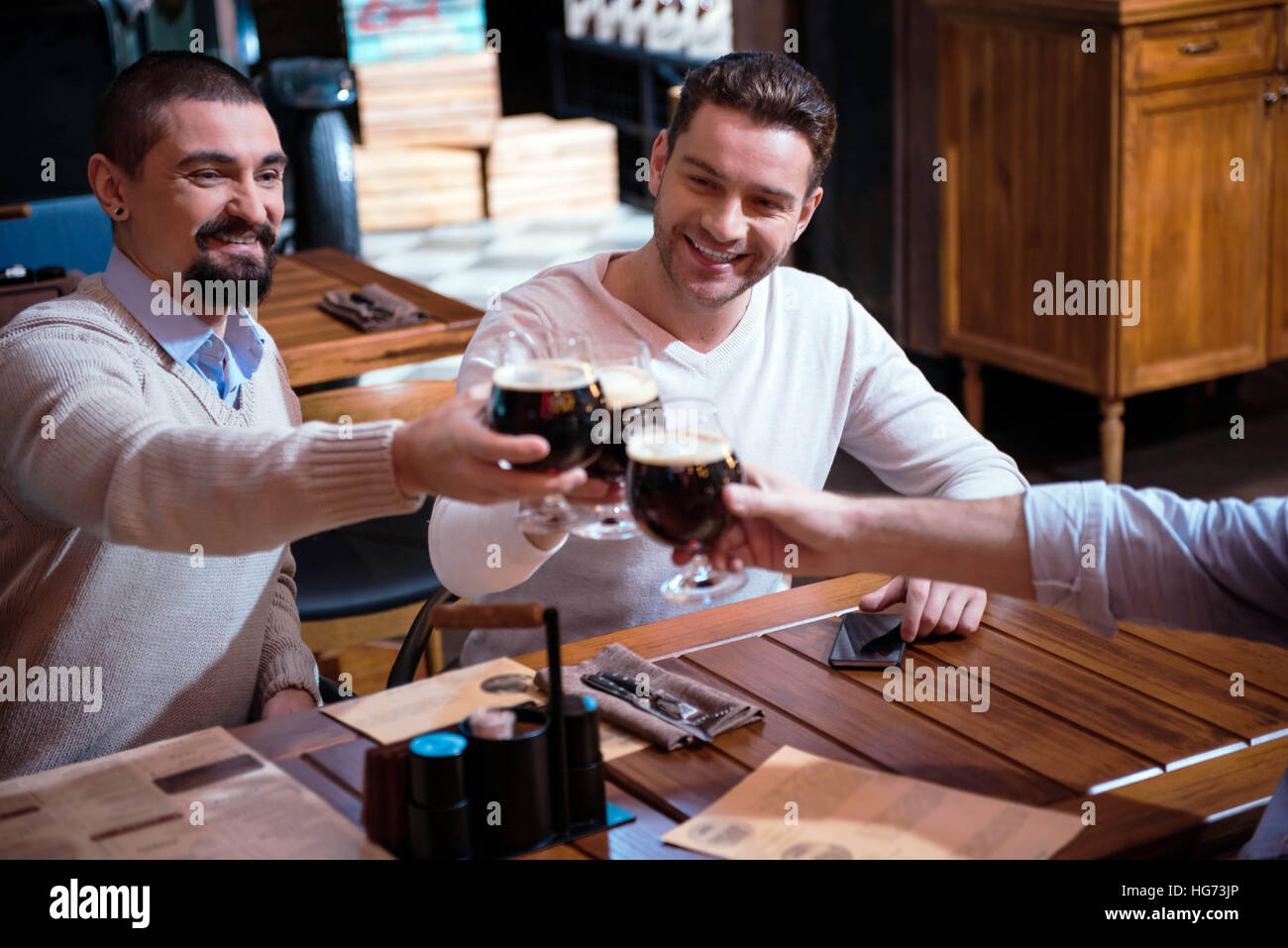 Positive fröhliche Freunde jubeln mit Bier Stockfoto
