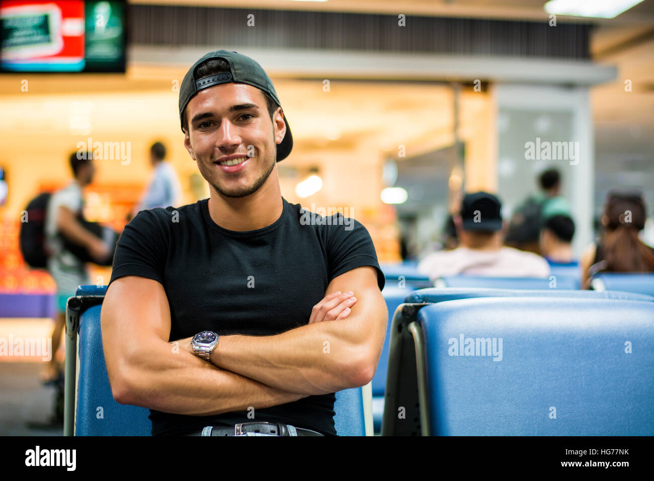 Junger Mann warten in der Sitzecke am Flughafen oder Bahnhof Stockfoto