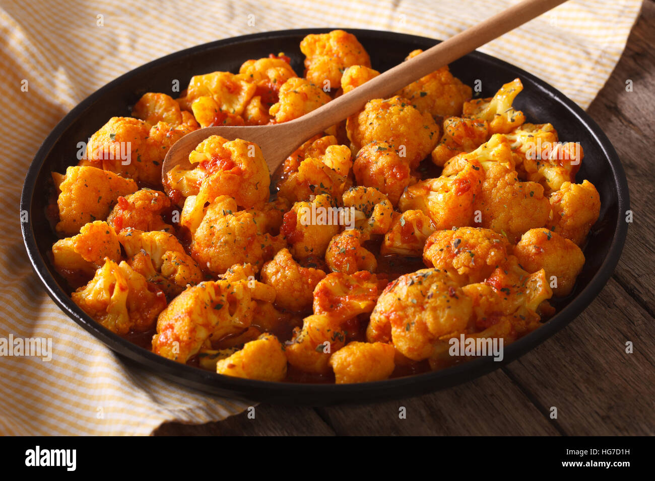 Vegetarisches Essen: Blumenkohl mit Tomaten in Currysauce mit einer Platte Großaufnahme. Horizontale Stockfoto