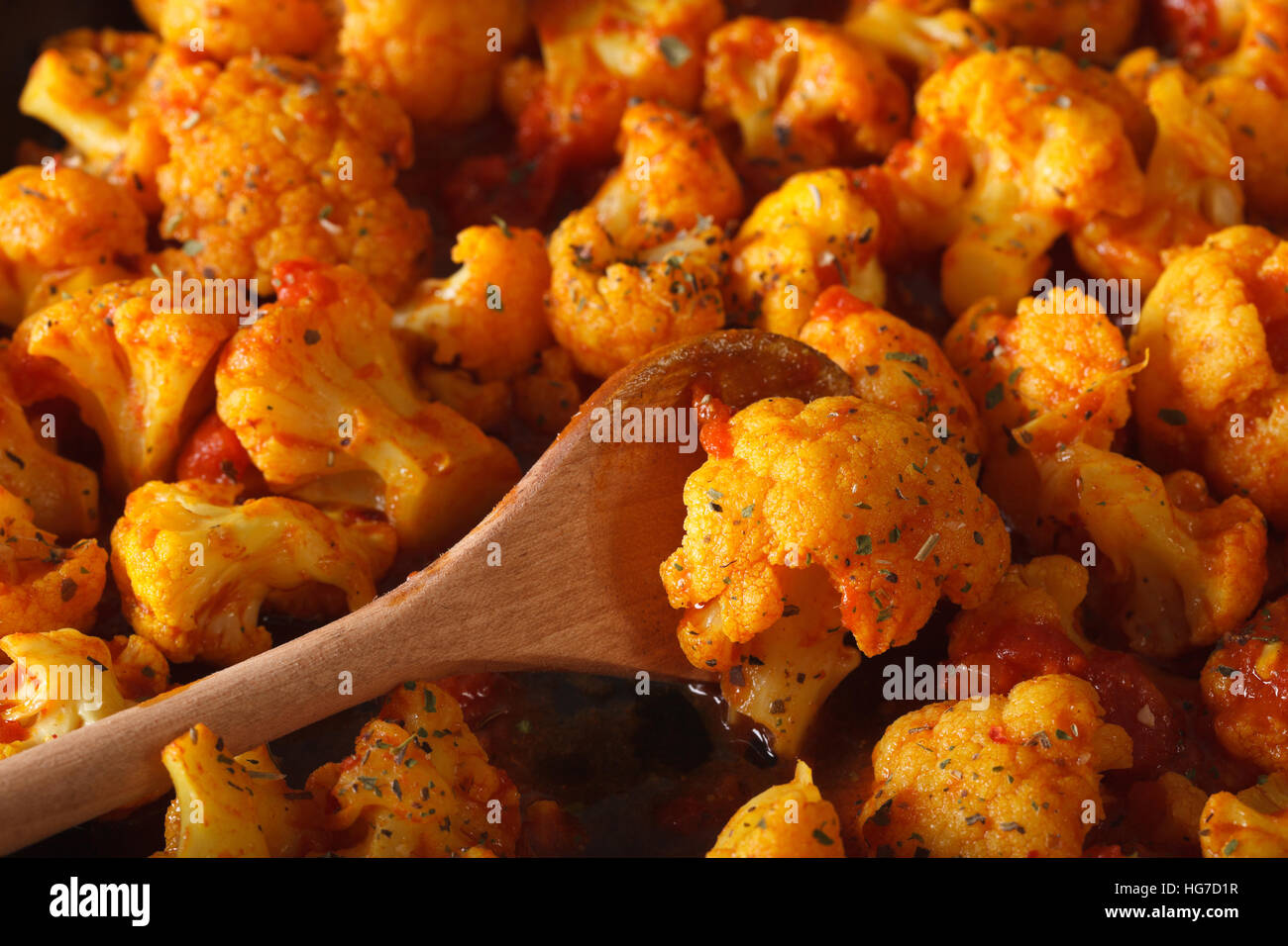 Blumenkohl mit Tomaten in Curry-Sauce-Makro. horizontale Ansicht von oben Stockfoto