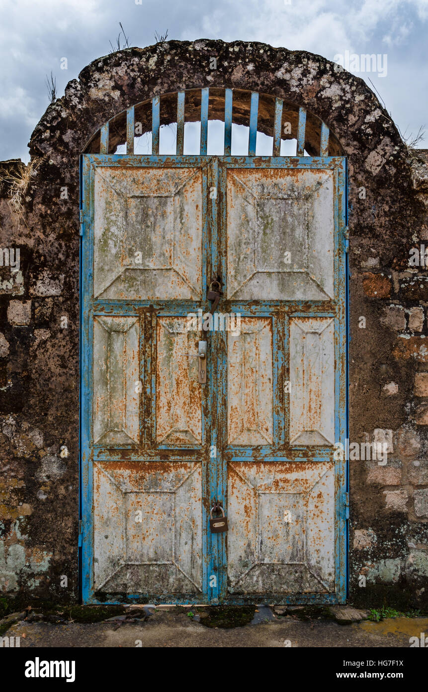 Alte rostige Tür mit Pad Schlösser und Felsbogen im historischen Palast der Fon, Bafut, Kamerun, Afrika Stockfoto