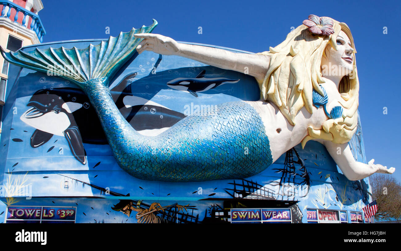 Eine riesige Meerjungfrauenstatue schmückt ein Geschäft in Kissimmee, Florida, und lockt Besucher mit skurrilem Charme am Straßenrand und dem Flair der Strandstadt. Stockfoto