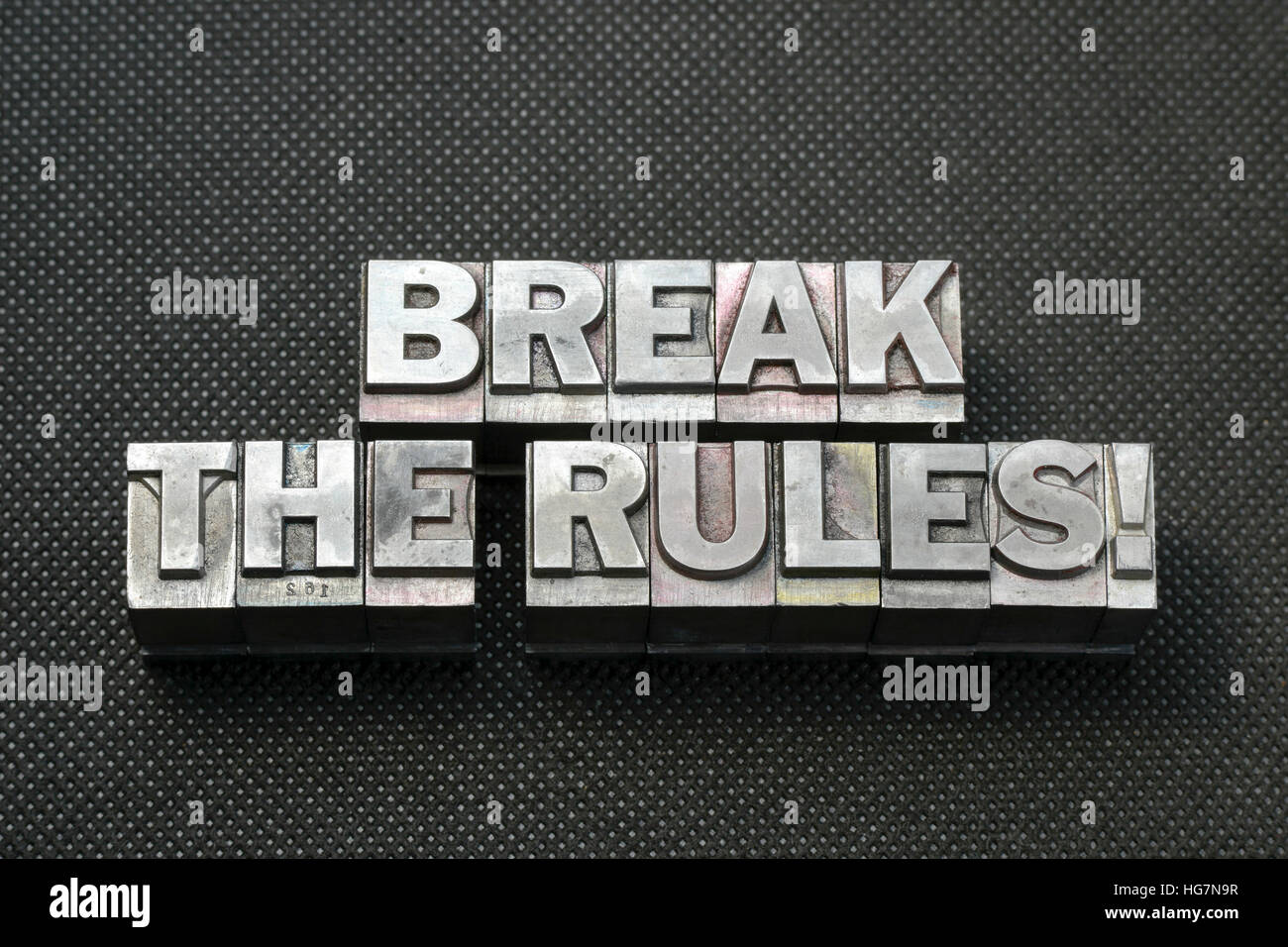 brechen Sie die Regeln Phrase aus metallischen Buchdruck Blöcke auf schwarze gelochte Oberfläche hergestellt Stockfoto