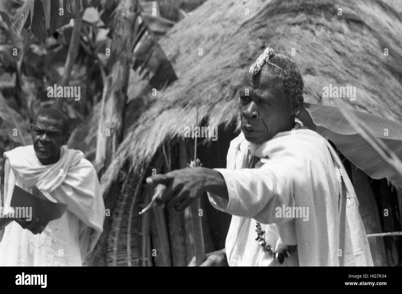 Ein afrikanischer Medizinmann, die Aufsicht über die Abgabe von alkoholischen Getränken Stockfoto