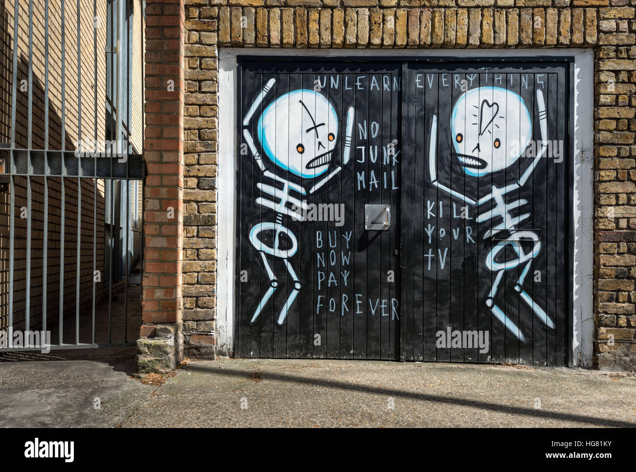 Street-Art-Wandbild von zwei Skelette auf einem Garagentor protestieren Stockfoto
