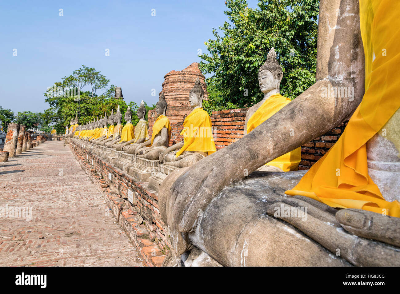Zeile der Buddha-Statue sitzt am Wat Yai Chaimongkol Tempel in Phra Nakhon Si Ayutthaya Historical Park, Provinz Ayutthaya, Thailand Stockfoto
