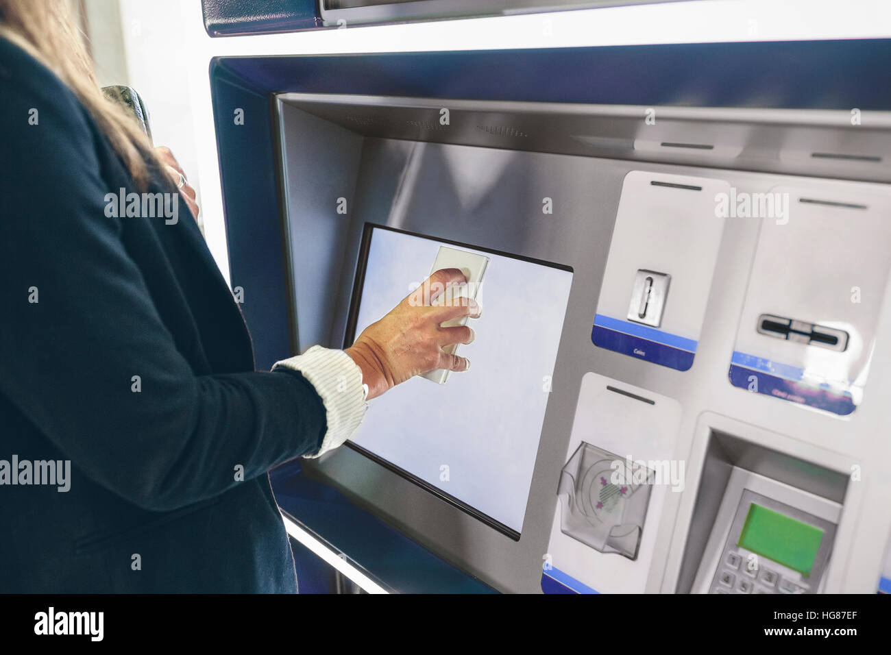 Mittelteil der Frau Scannen Handy beim Kauf der Fahrkarte Stockfoto