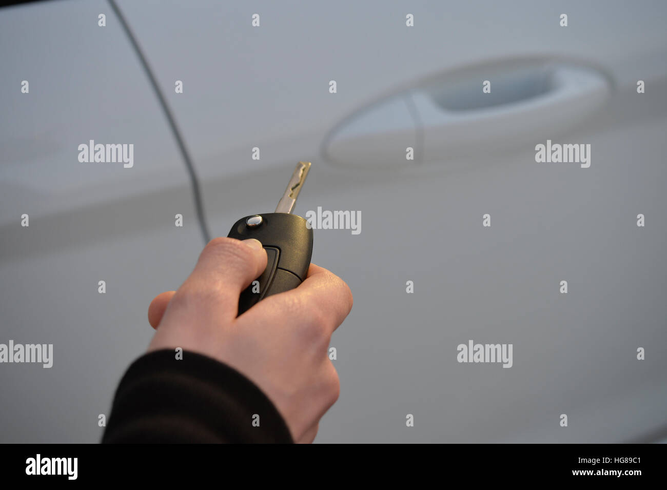 Frau entsperren oder sperren Auto mit einem remote-Schlüssel Stockfoto
