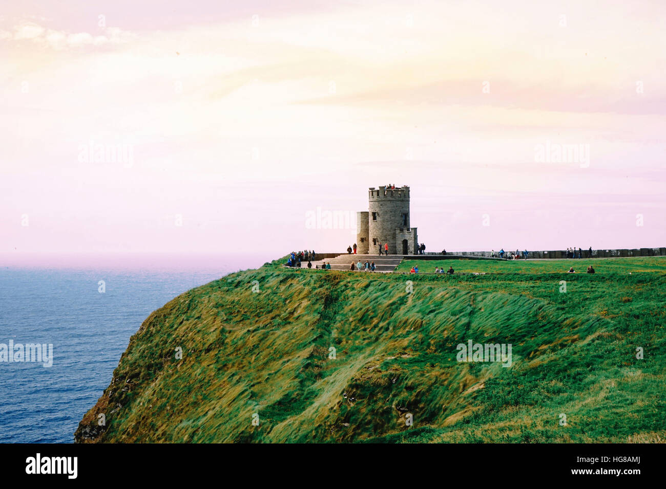 Touristen besuchen Obrien Turm auf Cliffs Of Moher gegen bewölktem Himmel auf dem Seeweg Stockfoto