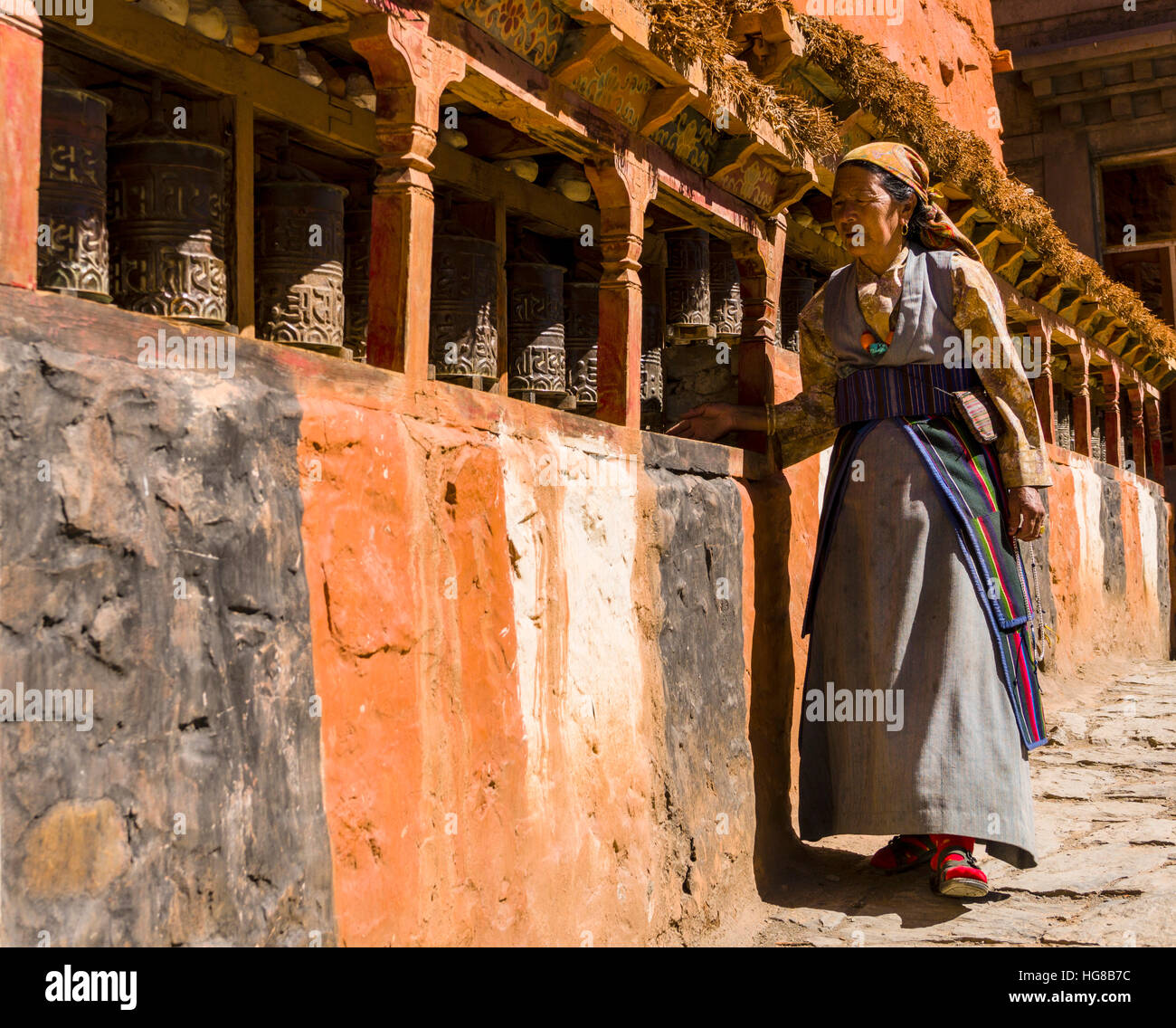 Einheimische Frau Mani Mauer entlang und drehen Gebetsmühlen, Kagbeni, Mustang District, Nepal Stockfoto