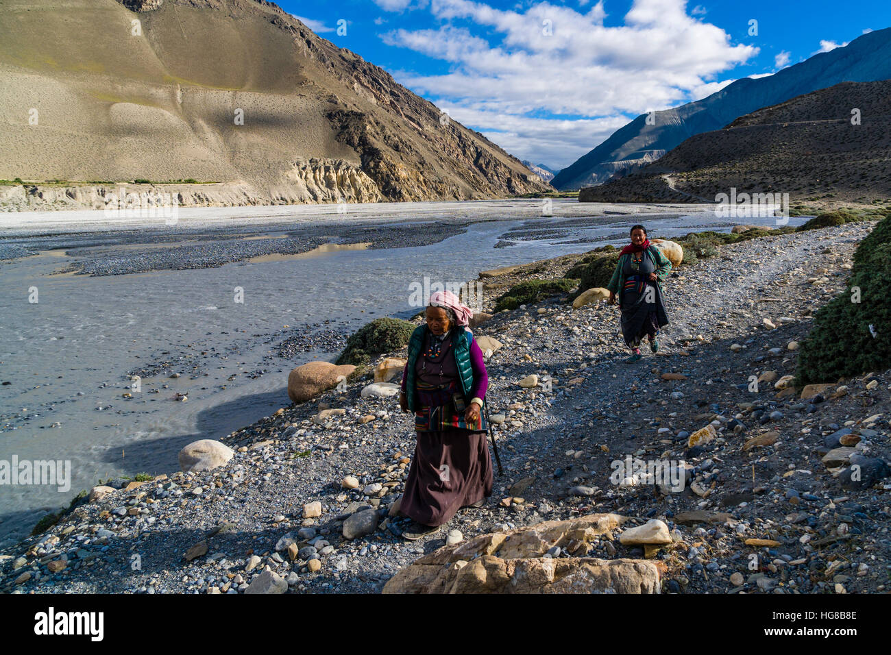 Zwei einheimische Frauen zu Fuß am Fluss, in der Nähe von Jomsom, Kali Gandaki Tal, Mustang District, Nepal Stockfoto