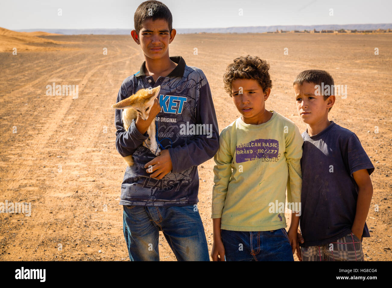 Berber Jungen mit Fennec (Desert Fox) auf der Wüste Sahara in der Nähe von Merouga, Marokko Stockfoto