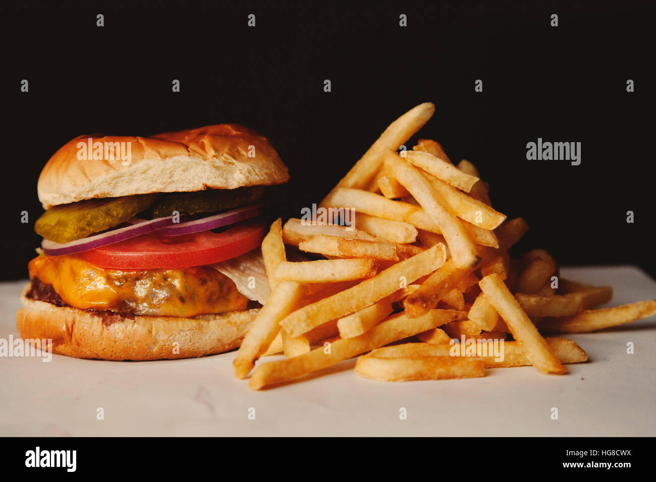 Nahaufnahme der Hamburger mit Pommes Frites auf Tisch vor schwarzem Hintergrund Stockfoto