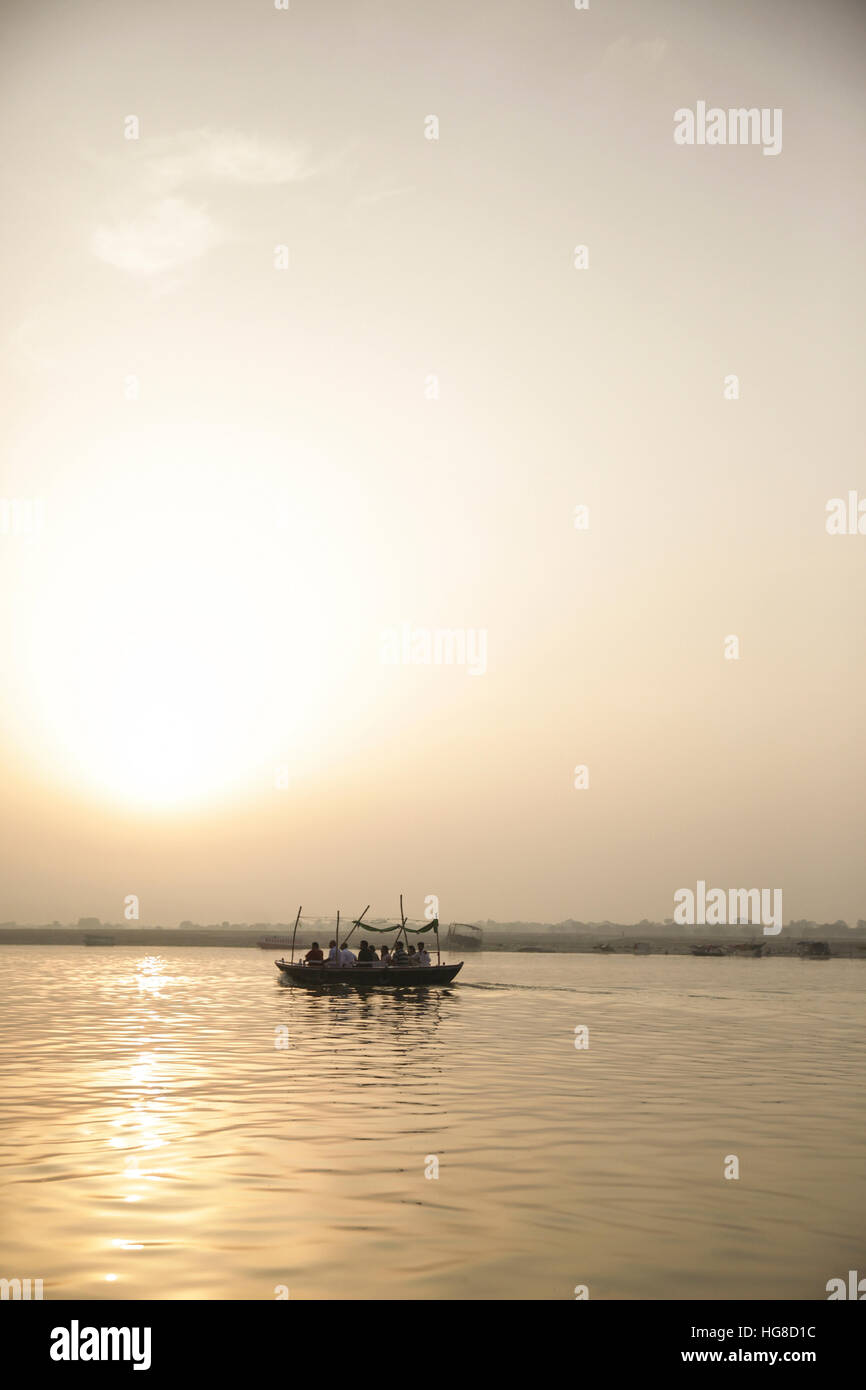 Reisende, die im Boot während des Sonnenuntergangs Stockfoto