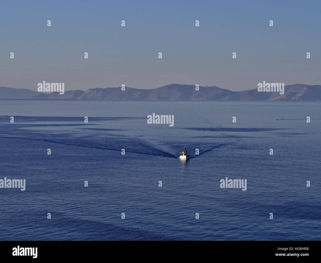 Einsamen weißen Fischerboot im tiefen Blau des Meeres in der Nähe von Insel Syros, Griechenland. Stockfoto