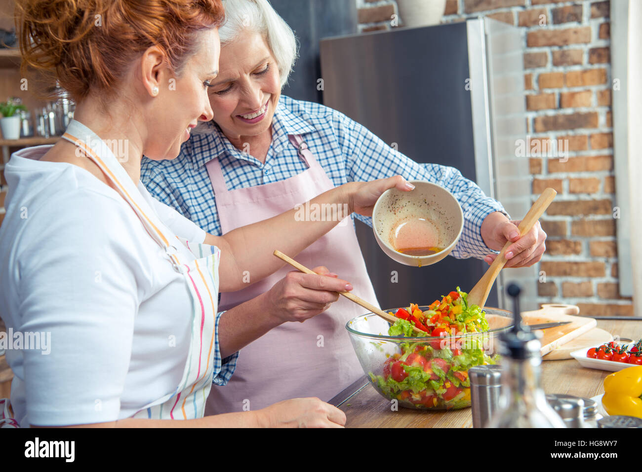 Zwei lächelnde Frauen Gemüsesalat gemeinsam kochen Stockfoto