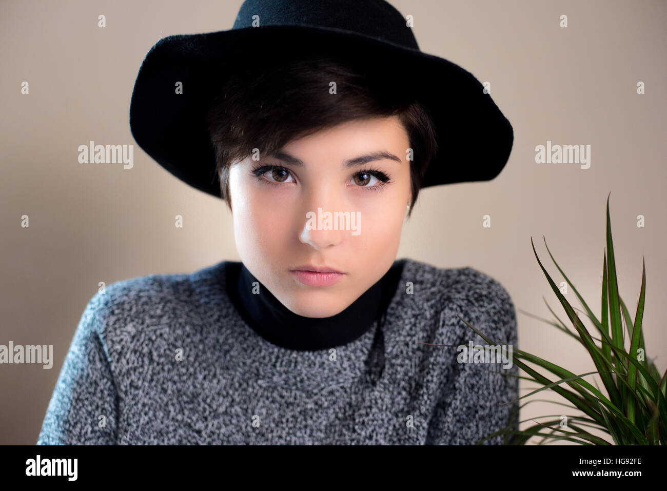 Menschliches Gesicht natürliche und neutrale Ausdruck der hübsche junge Frau mit schwarzen Hut Blick in die Kamera Stockfoto