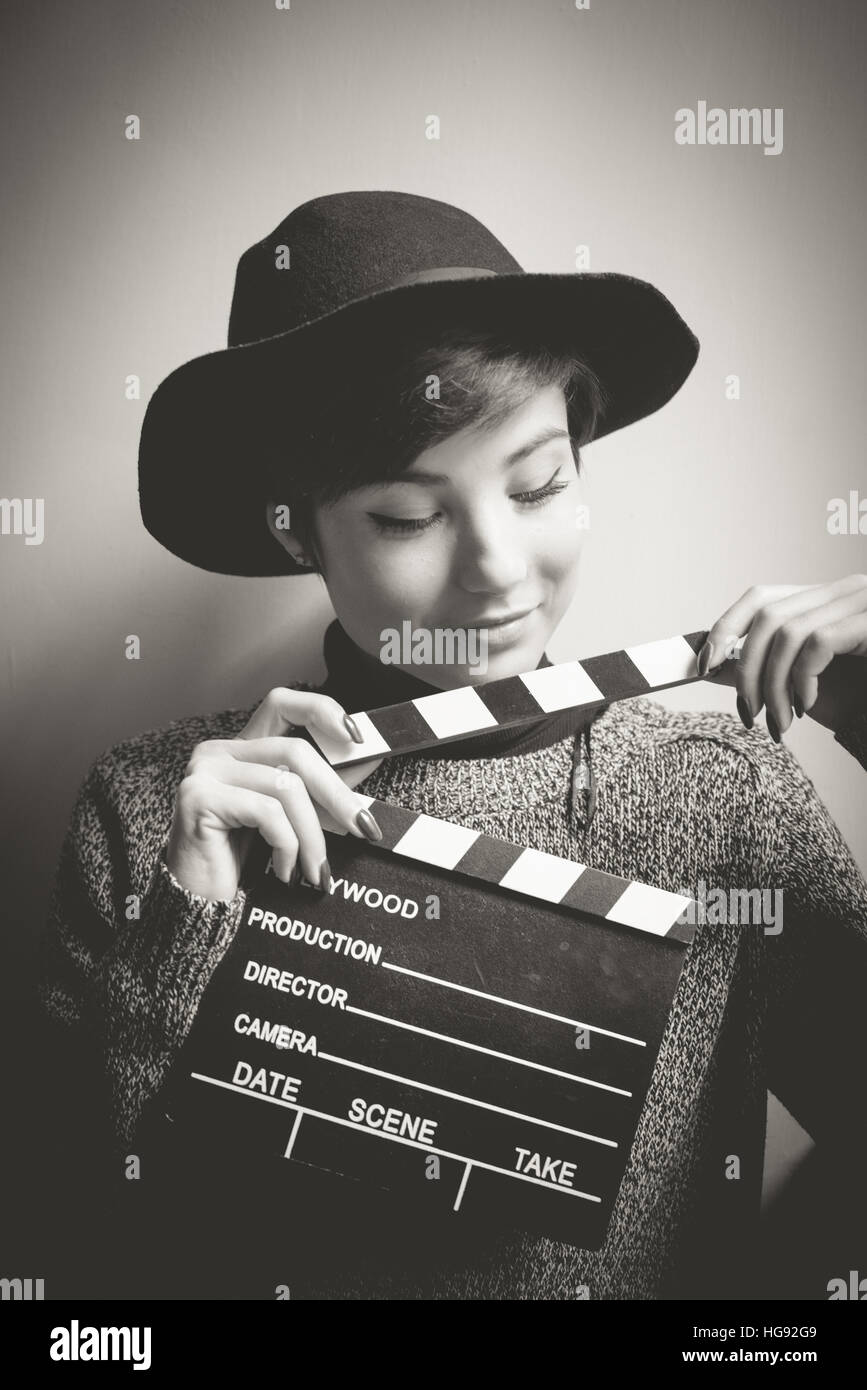 Junge Frau Porträt, Schauspielerin, lächelnd und halten Film Klöppel, Vintage schwarz und weiß Stockfoto