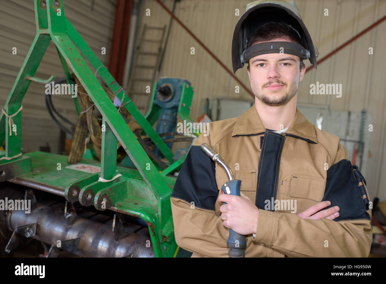 glücklich Lehrling Schweißer bei der Arbeit in der Anlage Stockfoto