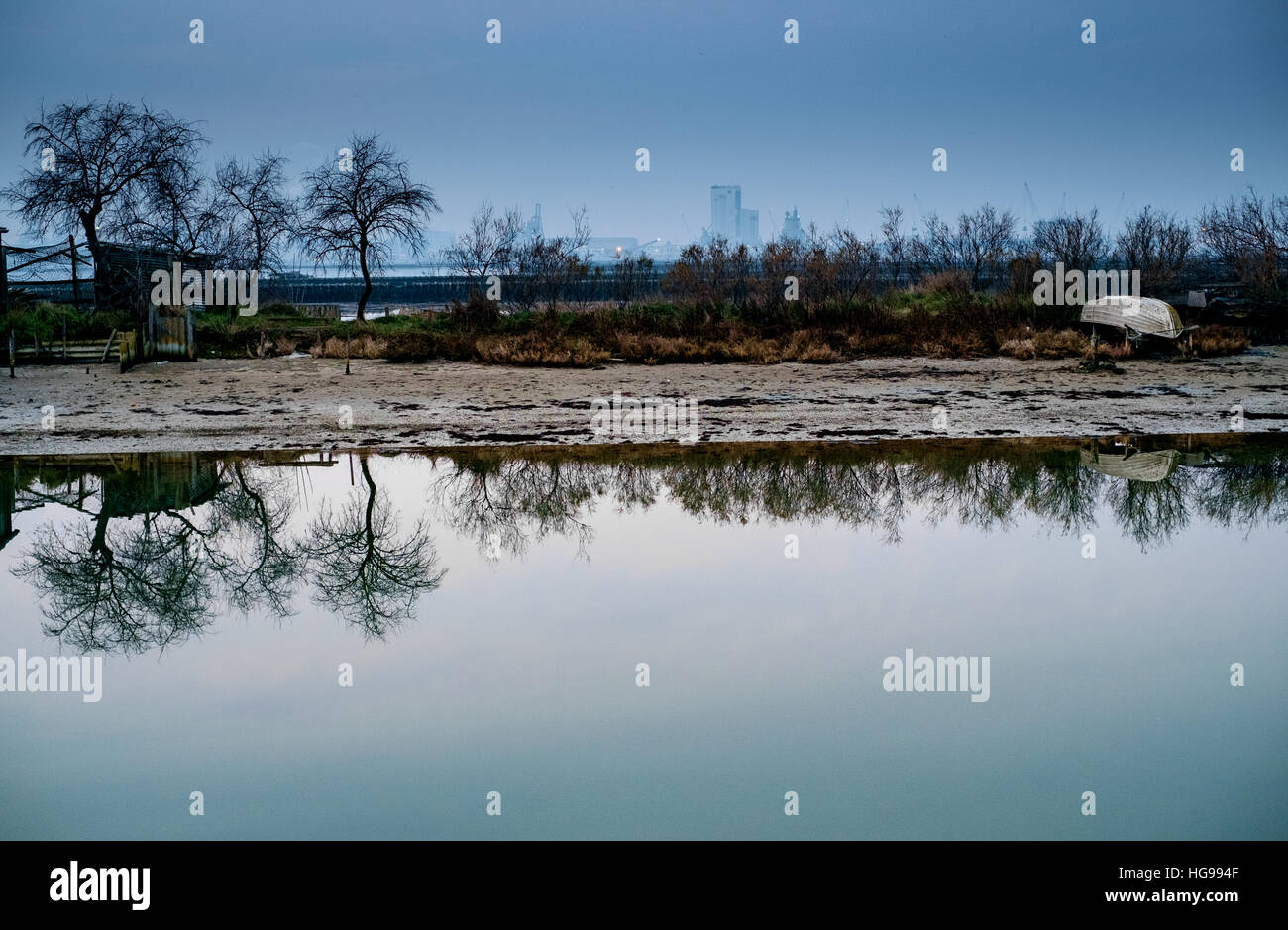 Winter abends Reflexionen über Marina di Ravenna Sumpf. Industrielandschaft im Hintergrund. Stockfoto