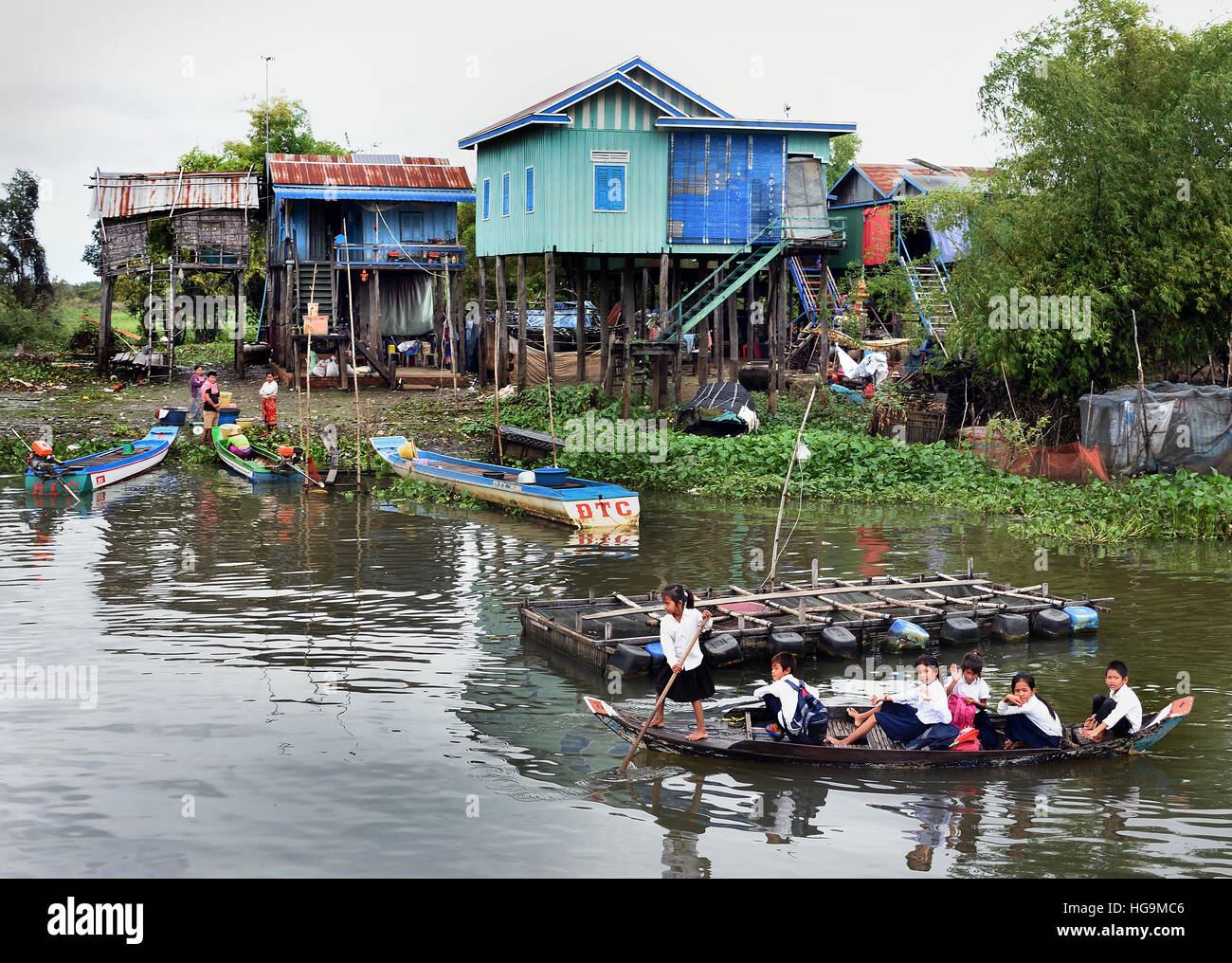 Kleines Boot mit Schulkindern entwässert schwimmende Dorf der Sangkhae - Sangker River Battambang Provinz Cambodia.The Tonle Sap See (reichsten See zum Angeln in der Welt) in den Mekong-Fluss in Phnom Penh. Die kambodschanische Bevölkerung hat auch für das einzigartige Ökosystem des Sees mit schwimmenden angepasst (Fischer-Fischerei) Dörfer und gestelzt Häuser. Stockfoto