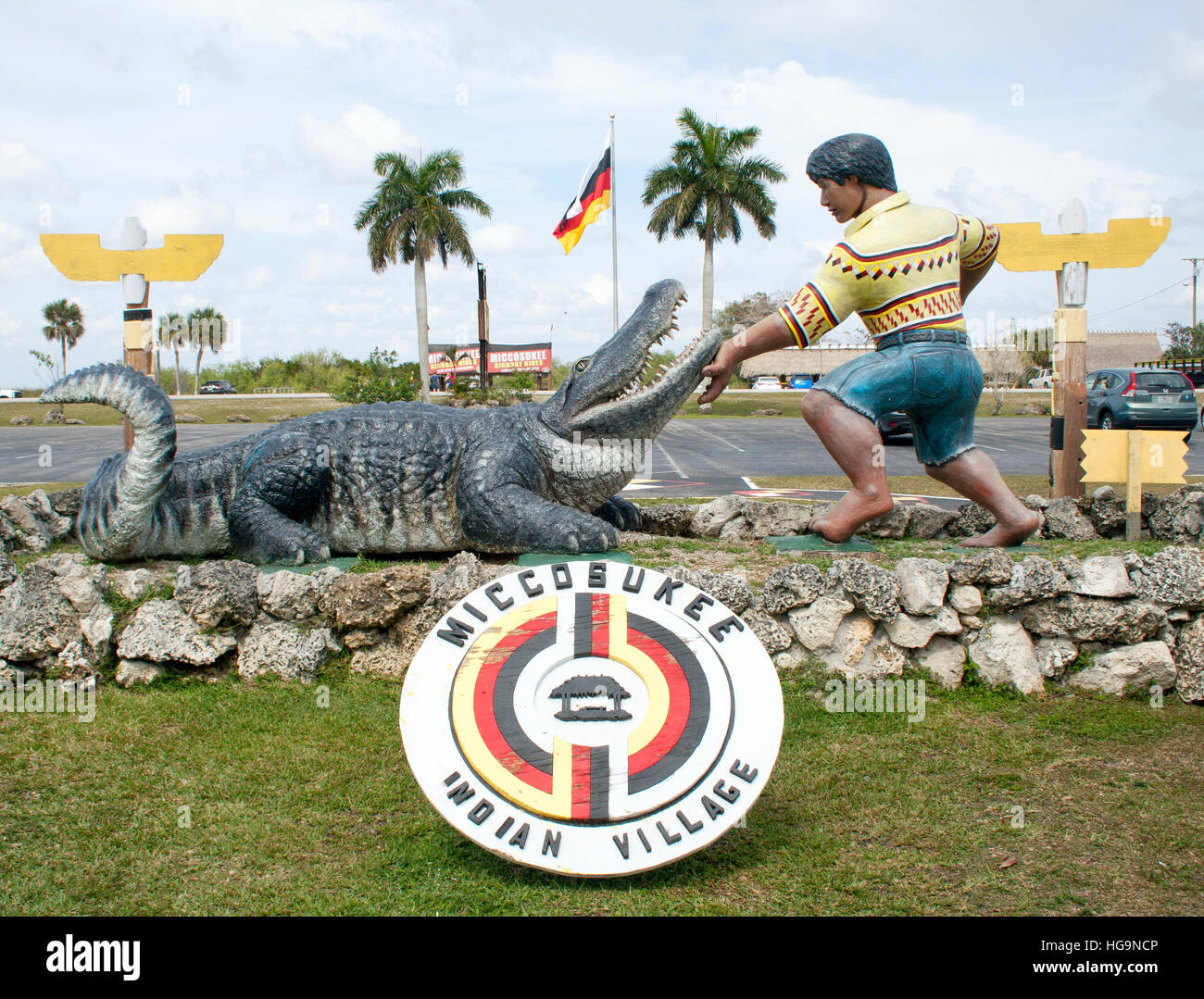 Eine markante Statue am Straßenrand in Tamiami, FL, zeigt einen Wrestler der Ureinwohner, der sich um einen riesigen Alligator kümmert und damit das Erbe der Seminolen und Floridas wilde Geist ehrt. Stockfoto