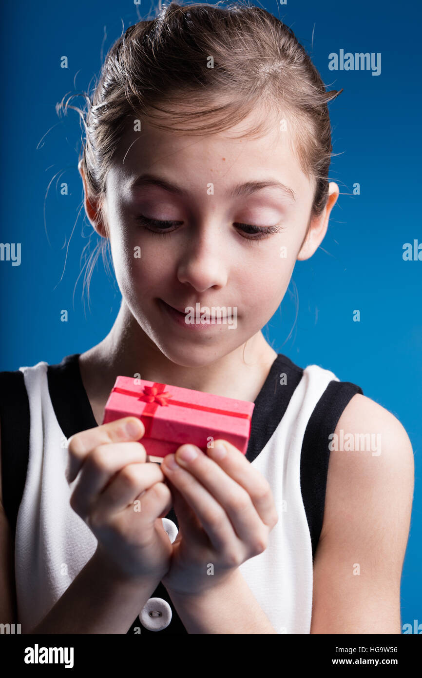 Mädchen nur ein kleines rotes Paket als Geschenk erhalten und wollen, dass es eine schöne Überraschung sein Stockfoto