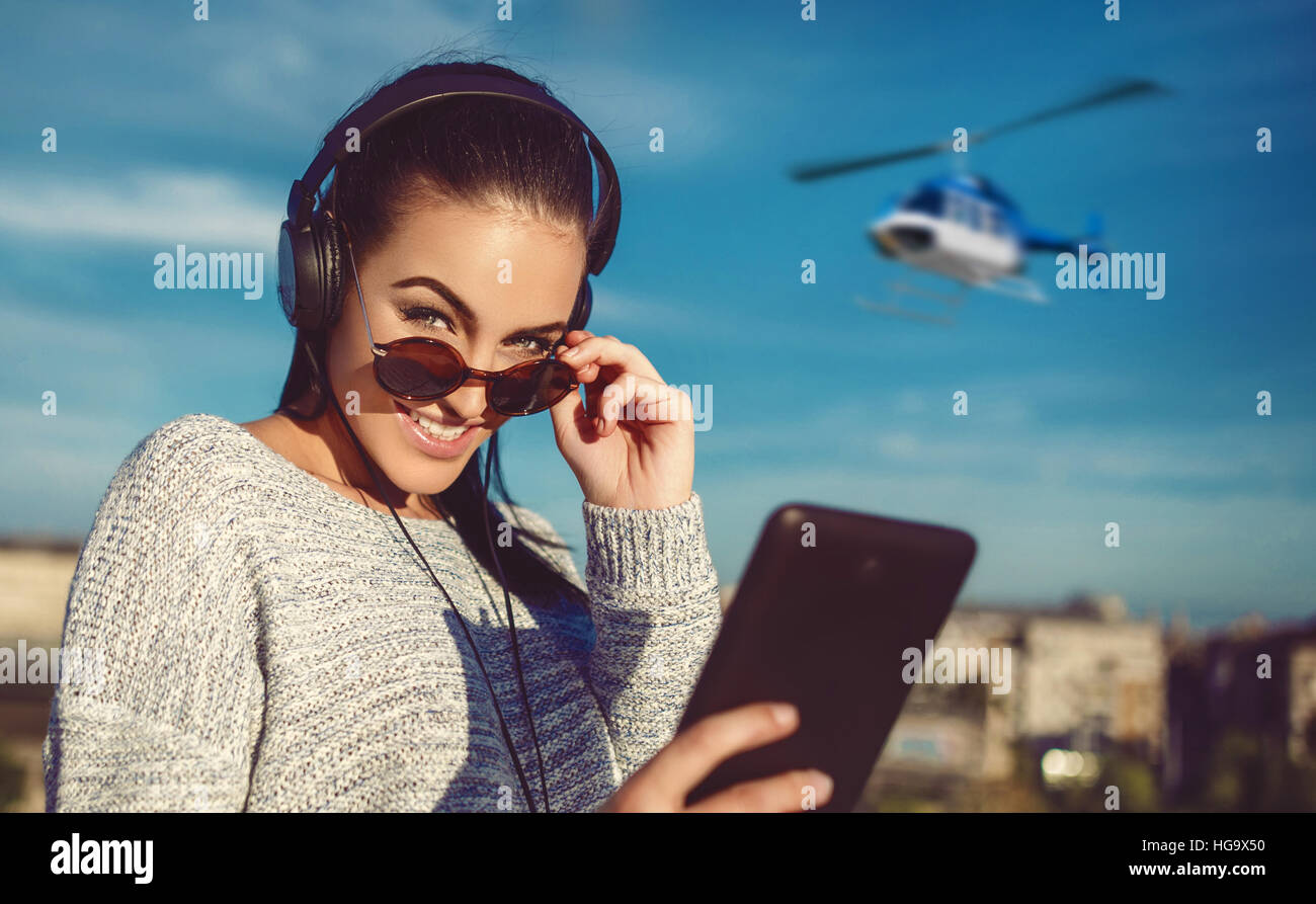 Junge Frau Helikopter-Tour-Ticket durch Tablette am Flughafen bestellen Stockfoto