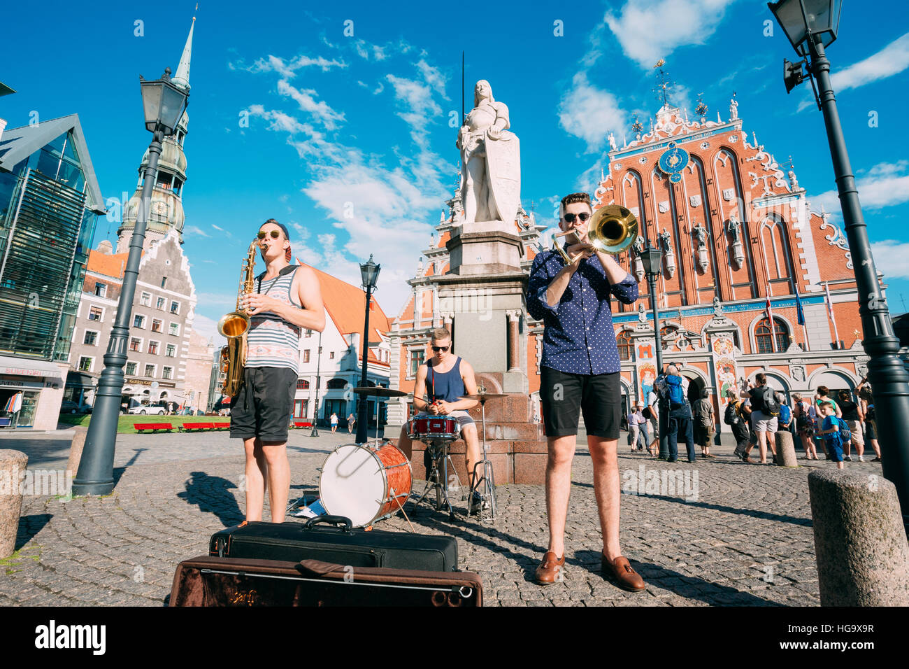 Riga, Lettland - 1. Juli 2016: Straßenmusik Trio Band drei junge Musiker-Jungs spielen die Instrumente für die Spende auf dem Rathausplatz, berühmt Stockfoto