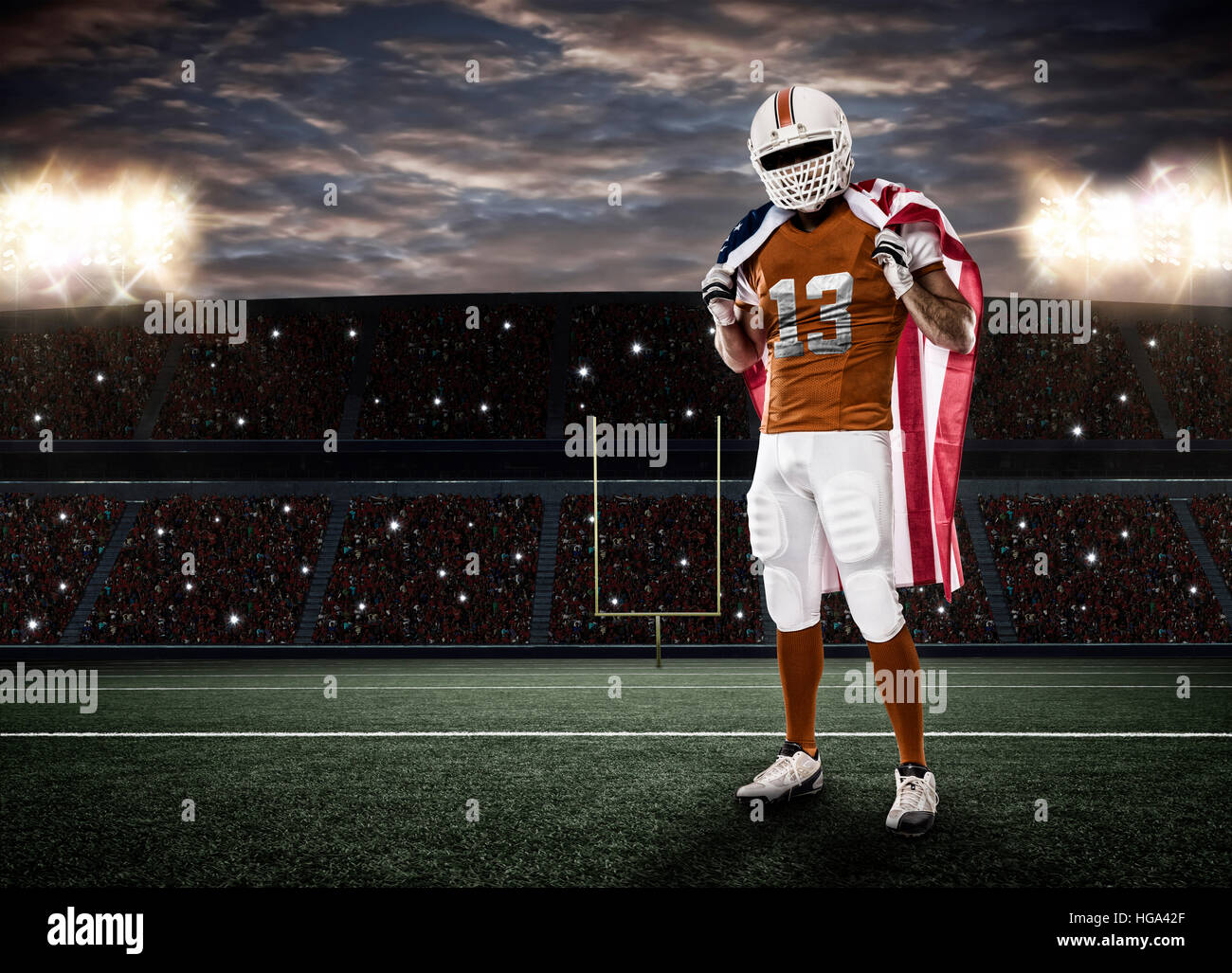 Football-Spieler mit einer orangefarbenen Uniform und eine amerikanische Flagge auf einem Stadion. Stockfoto