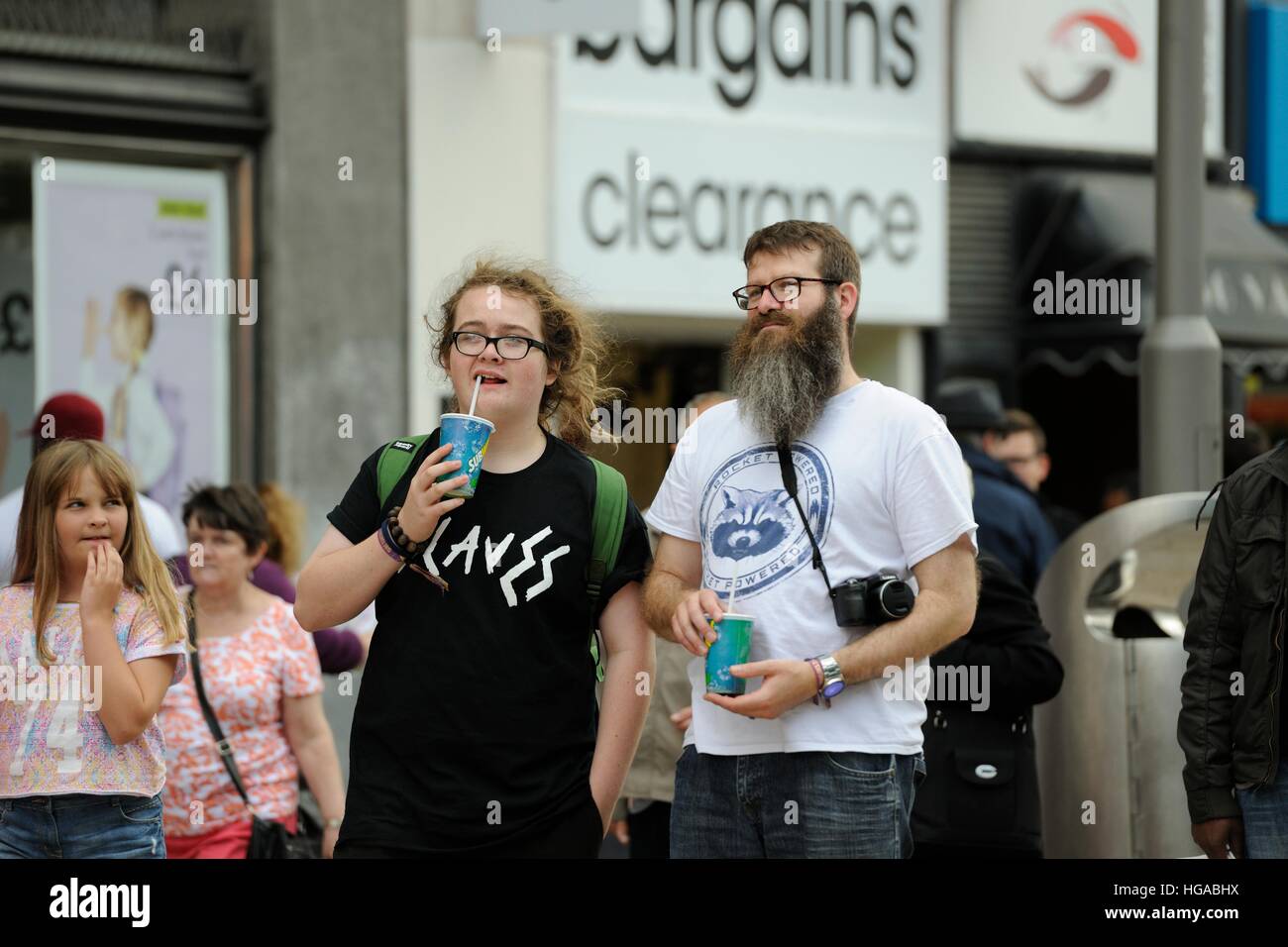 Teenager-Mädchen und Mann mittleren Alters beobachten Musiker auf der Moor-Sheffield, Teilnahme an der Straßenbahnlinien Festival Fringe 2014 Stockfoto