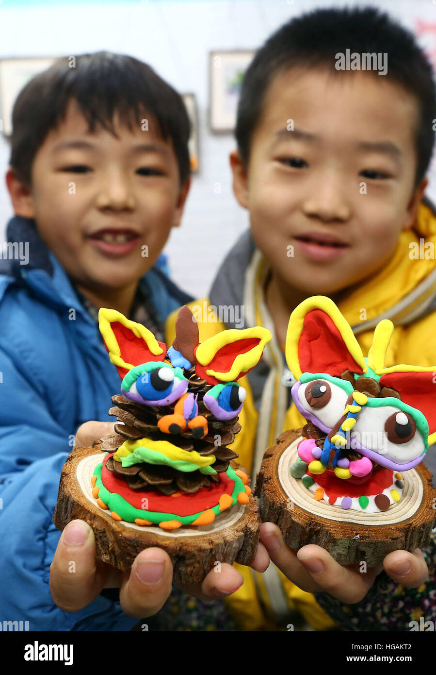 Tianjin, China. 7. Januar 2017. Zwei jungen präsentieren Lehm Kunstwerke "Nian", die selbst bei eine Tempel-Messe-Events für das kommende Frühjahr Festival in Tianjin, Nord-China, 7. Januar 2017. "Nian" (Jahr auf Chinesisch), ist ein mythisches Tier auf Mensch und Vieh an der Wende des Jahres gefressen haben soll. Das Monster, fürchtete jedoch laut knallt und rote Farbe. © Liu Dongyue/Xinhua/Alamy Live-Nachrichten Stockfoto