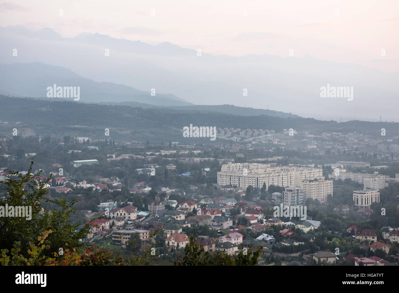 Ansicht von Almaty Gorny Gigant Bezirk und Zailiski Alatau Gebirge in der Abenddämmerung vom Berg Kok Tobe Stockfoto