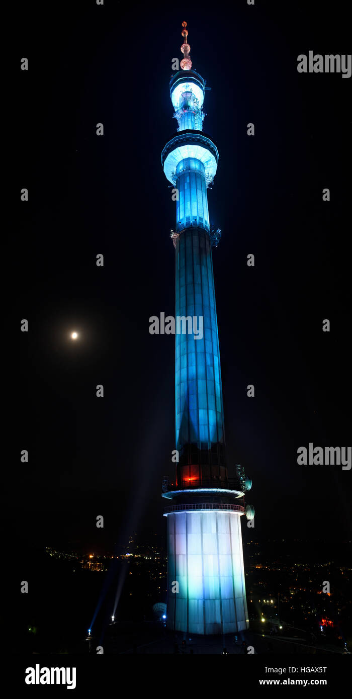 Blaulicht auf Almaty Fernsehturm am Berg Kok Tobe in der Nacht mit Mond Kasachstan Stockfoto