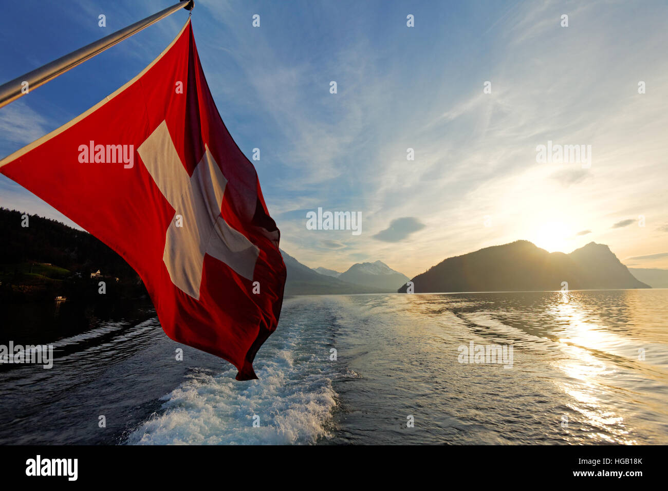 Schweizer Flagge auf Tourenboot Kreuzfahrt Vierwaldstätter See,  Sonnenuntergang über die Alp Berge, Schweiz Stockfotografie - Alamy