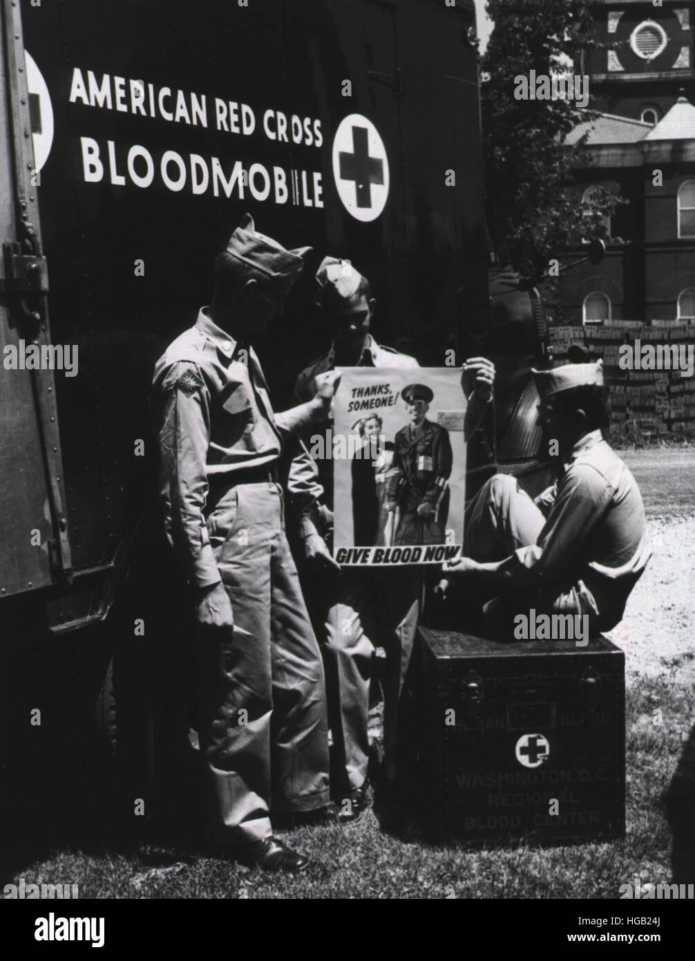 Drei Soldaten neben einem amerikanischen Roten Kreuz Bloodmobile, 1953. Stockfoto