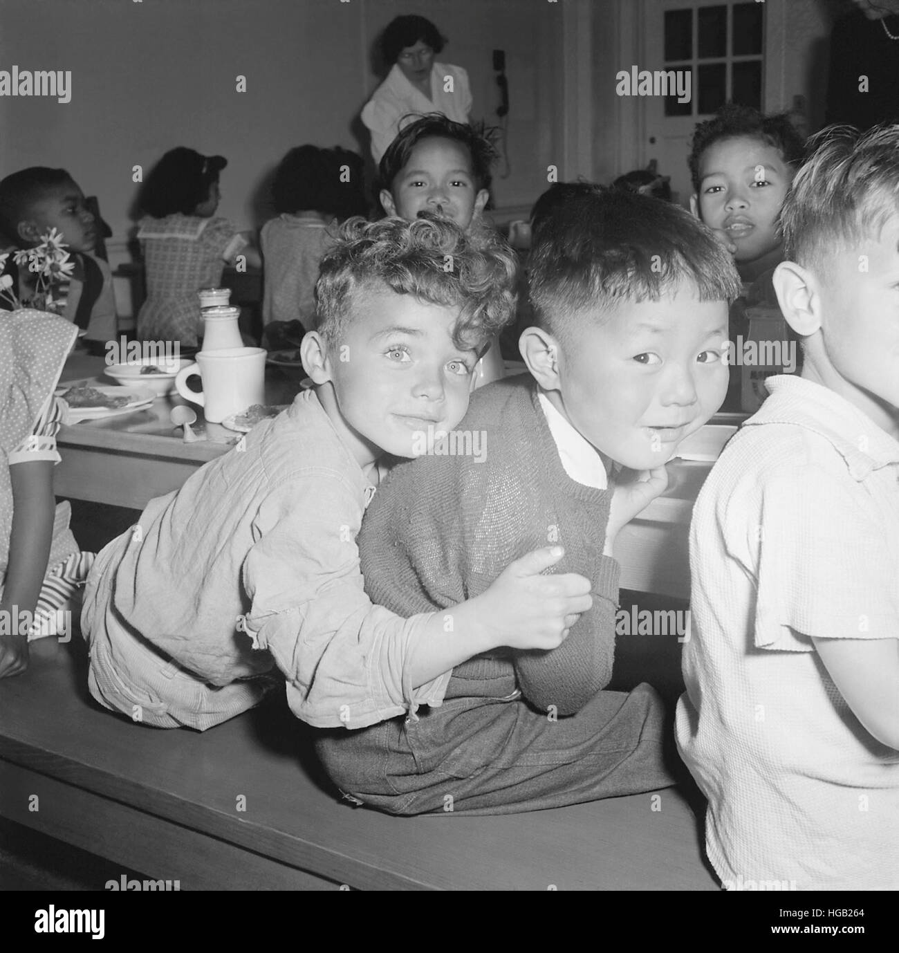 Ein japanisch-amerikanischer Junge bekommt eine Umarmung von seinem Kumpel während der Mittagszeit, April 1942. Stockfoto