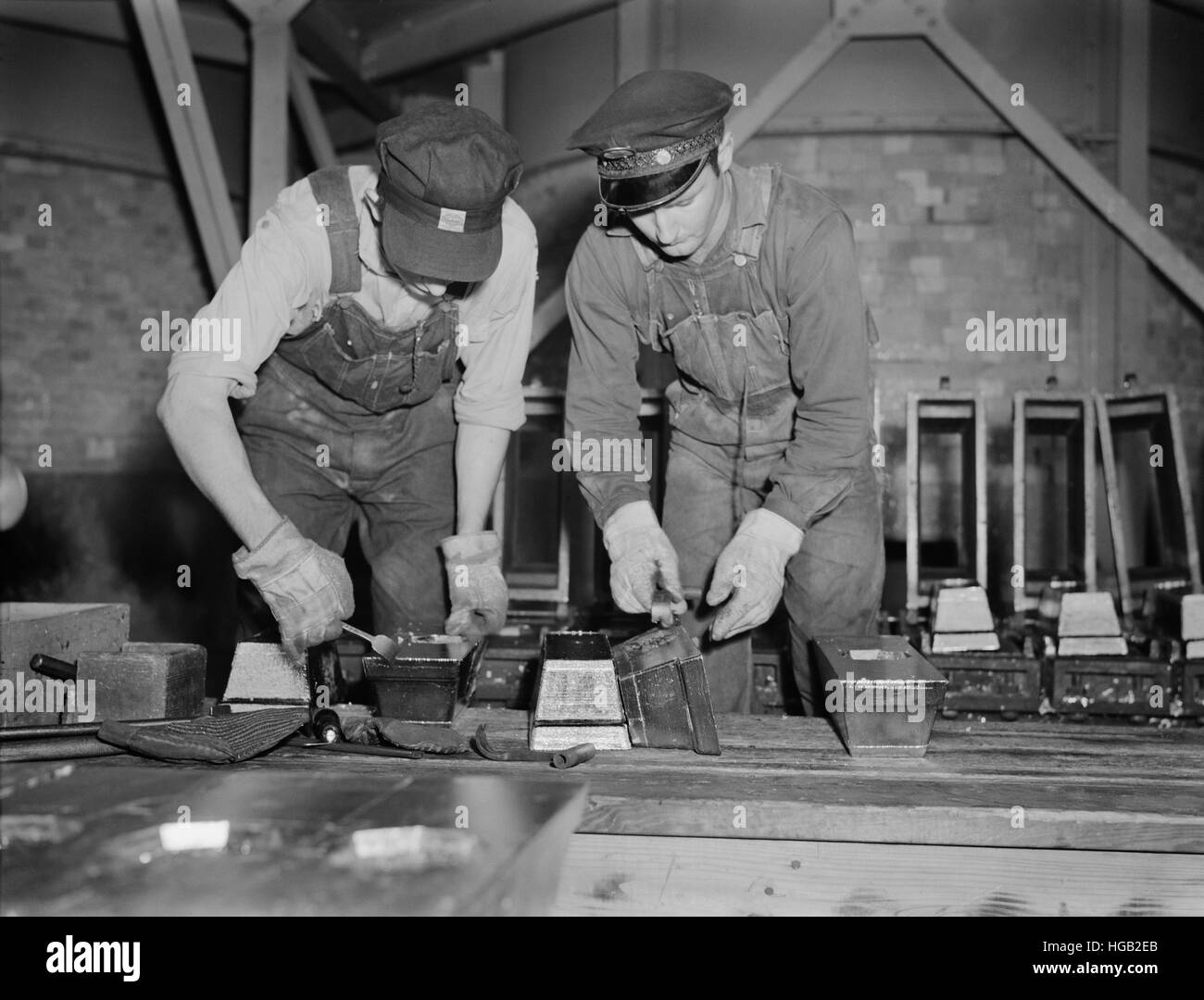 Bars von reinem Zinn sind getrimmt und gereinigt vor der Entnahme aus der Form, 1942. Stockfoto