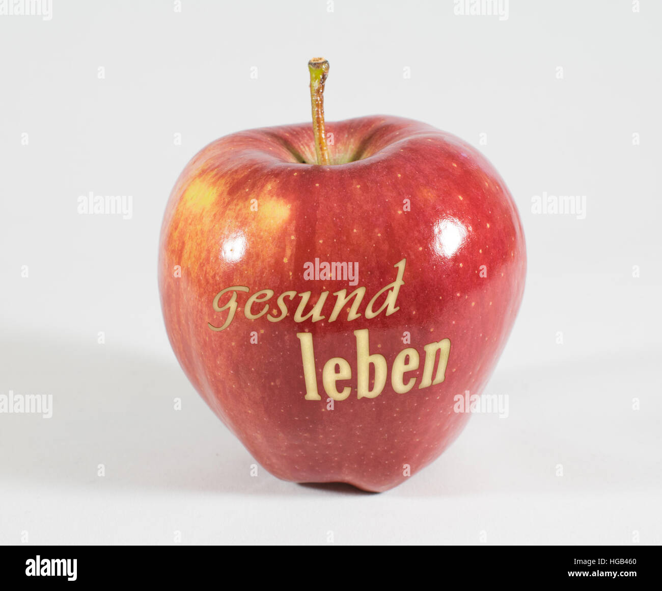 1 frische rote Apfel mit den Worten - lebe gesund - in deutscher Sprache auf einem weißen Hintergrund Stockfoto