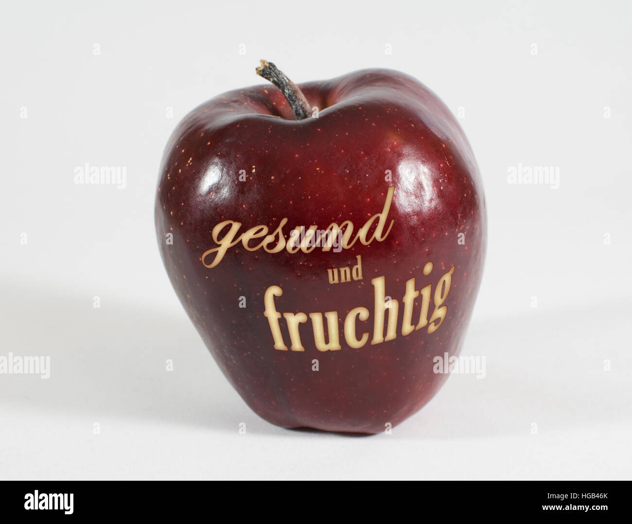 1 frische rote Apfel mit der Aufschrift "gesund und fruchtig" in deutschen Wörtern auf weißem Hintergrund Stockfoto