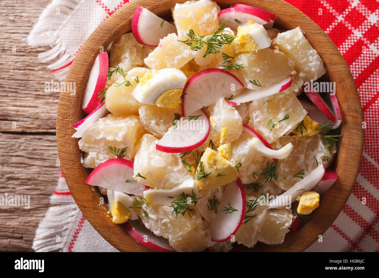 Kartoffelsalat mit Radieschen Nahaufnahme in einer Schüssel auf dem Tisch. horizontale Ansicht von oben Stockfoto